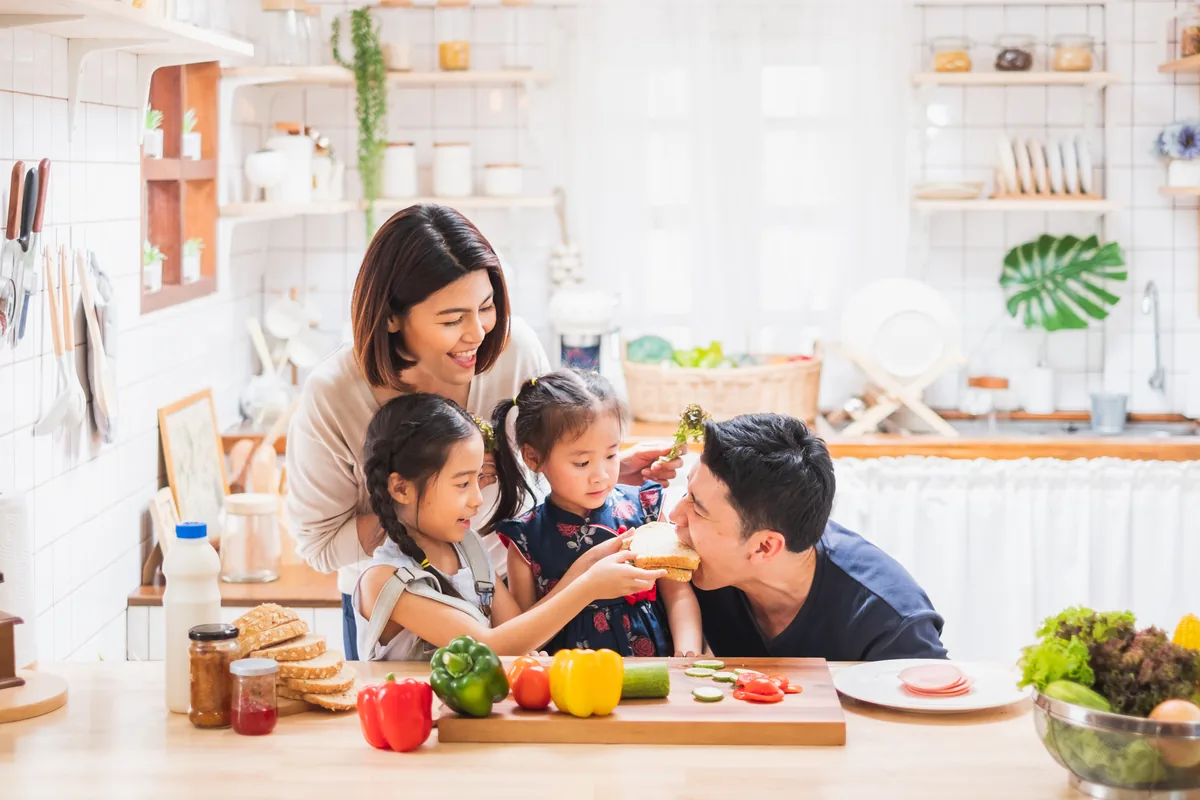 Gia đình châu Á nấu ăn vui vẻ trong bếp — canh chua tôm ngon